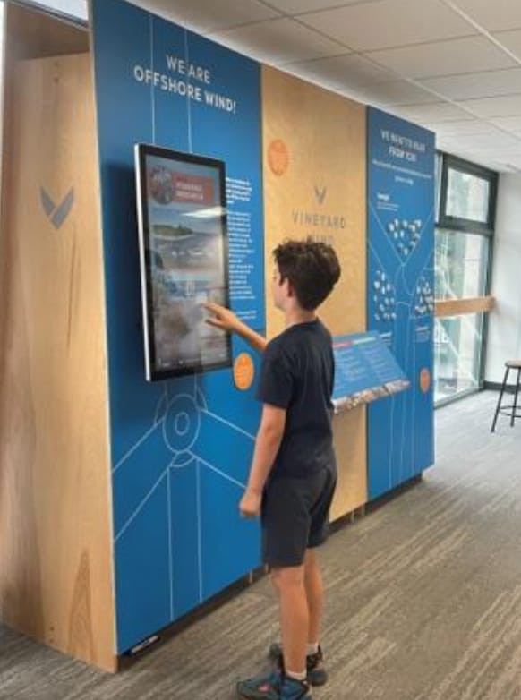 Child interacting with an offshore wind energy information display in a museum exhibit.