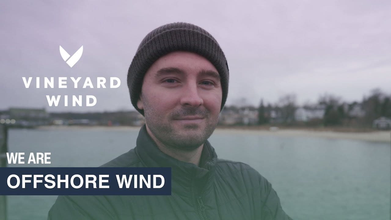 A man smiling in front of water