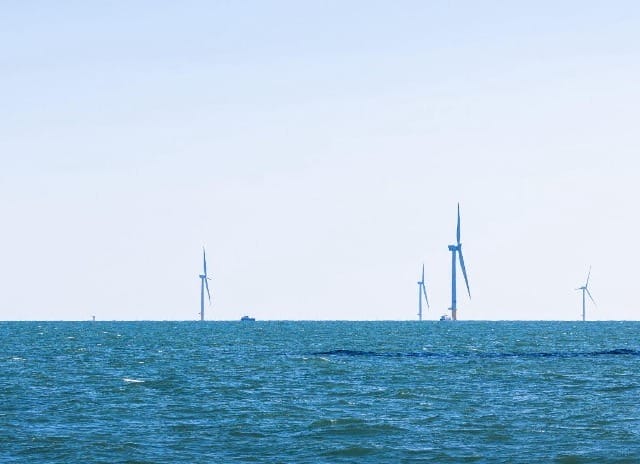 Offshore wind turbines on a clear day generating renewable energy from the ocean.